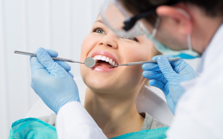 Regular dentist visit. Caries cure. Young woman visiting dentist